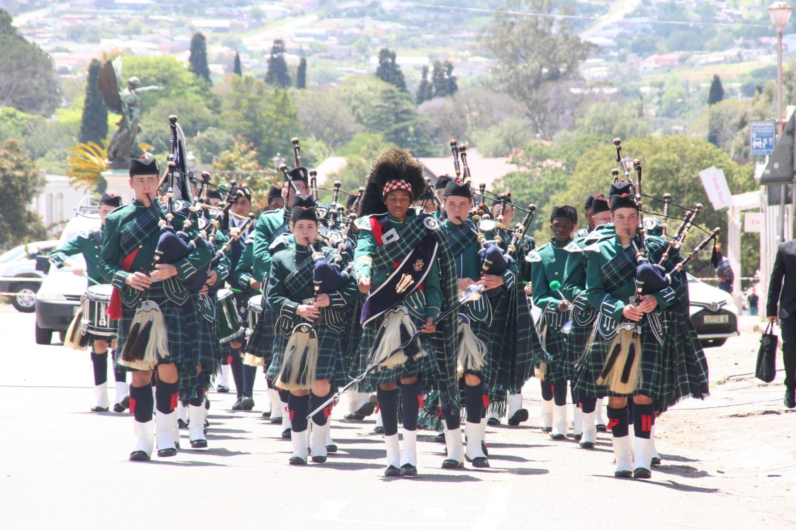 The St Andrew's College Pipe Band on the march in full dress, pipers and drummers led by the drum major
