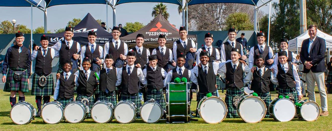 The pipe band in kilts and glengarries with their drums, lined up on the field at the South African Pipe Band Championships